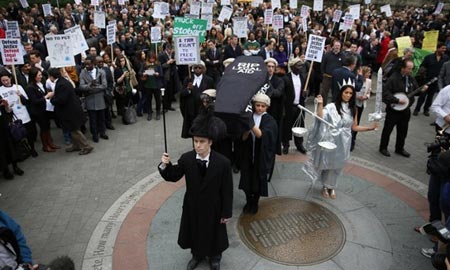 معترضان به سیاست های ریاضت اقتصادی در حال حمل تابوت نمادین قطع بودجه کمک های حقوقی در لندن