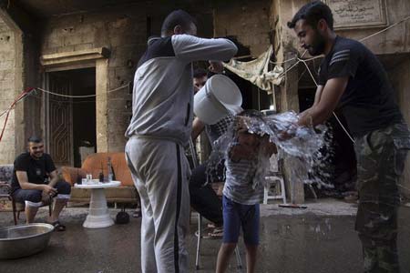 نیروهای مسلح مخالف حکومت سوریه در شهر دیر الزور در حال خنک شدن با آب