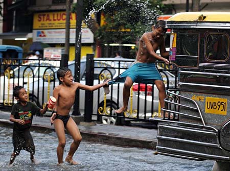 بازی و شیطنت در باران سیل آسا در مانیل فیلیپین