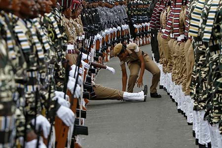     یک پلیس زن هند، در طول تمرین های رژه به مناسبت روز استقلال این کشور به همقطار خود کمک می 