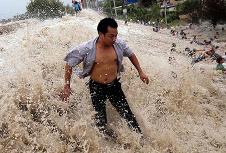 برخورد امواج عظیم رودخانه کیانتانگ با شهروندان چینی. طوفان ترامی در شرق چین باعث شد تا سطح جزر و مد در این رودخانه به ارتفاع 66متر برسد