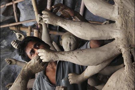 هنرمندی در میان بت ها در یک کارگاه آموزشی پیش از جشنواره دورگا در دهلی نو 